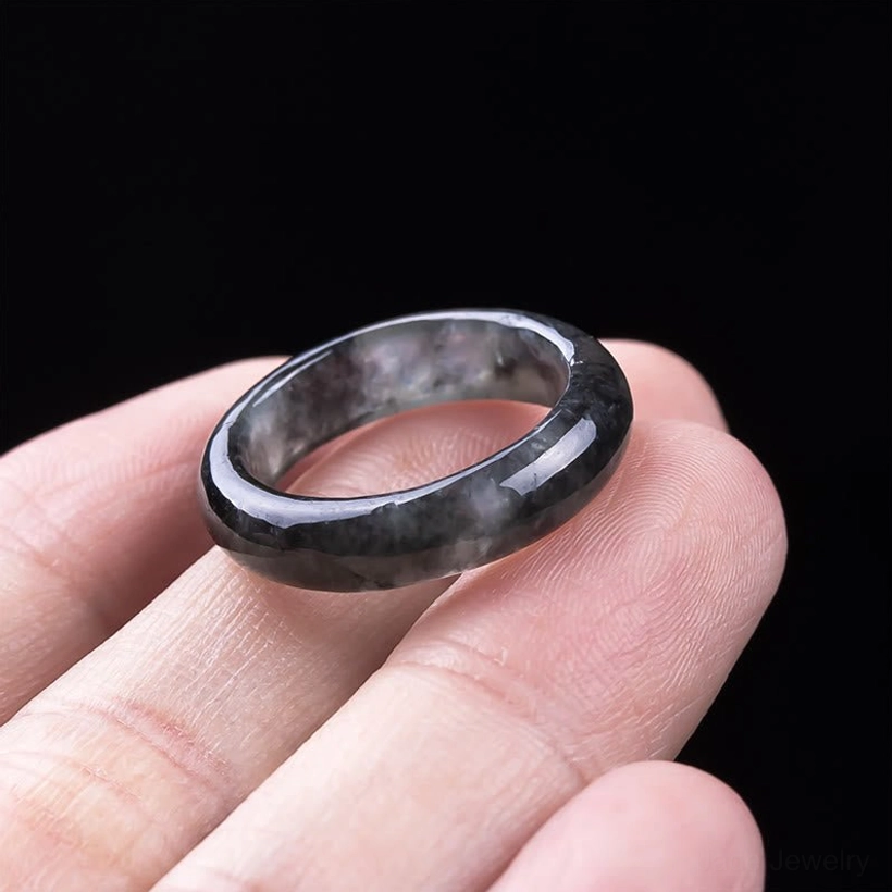 Natural jade prosperity ring worn on hand displaying how the smooth band sits on finger, dark grey jade stone