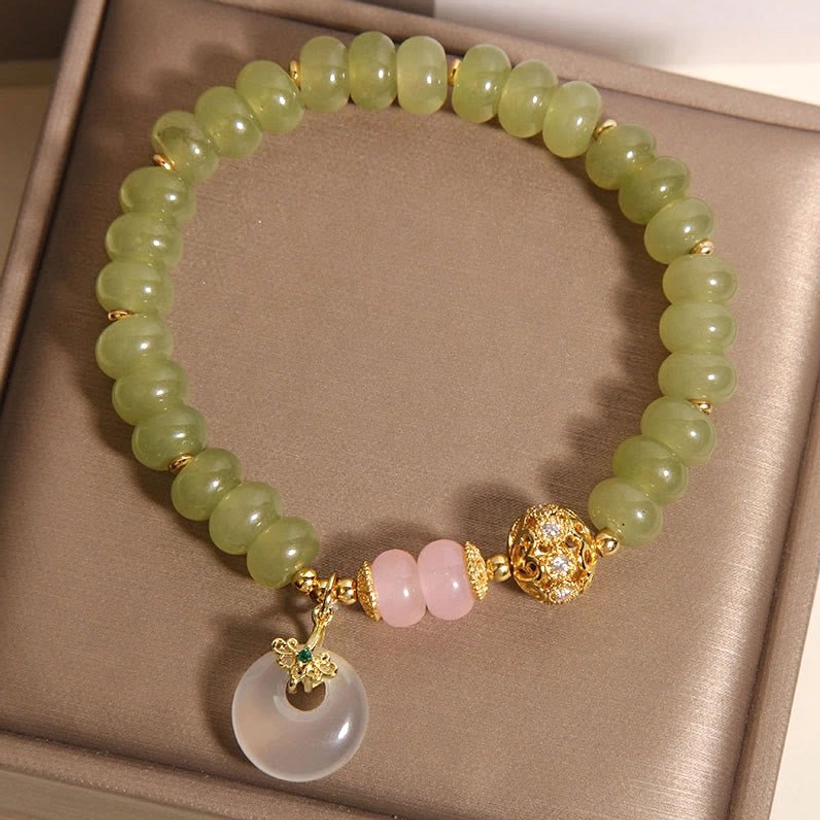 Full circular jade rose quartz peace buckle bracelet displayed flat in jewelry box with gold spacer and pendant