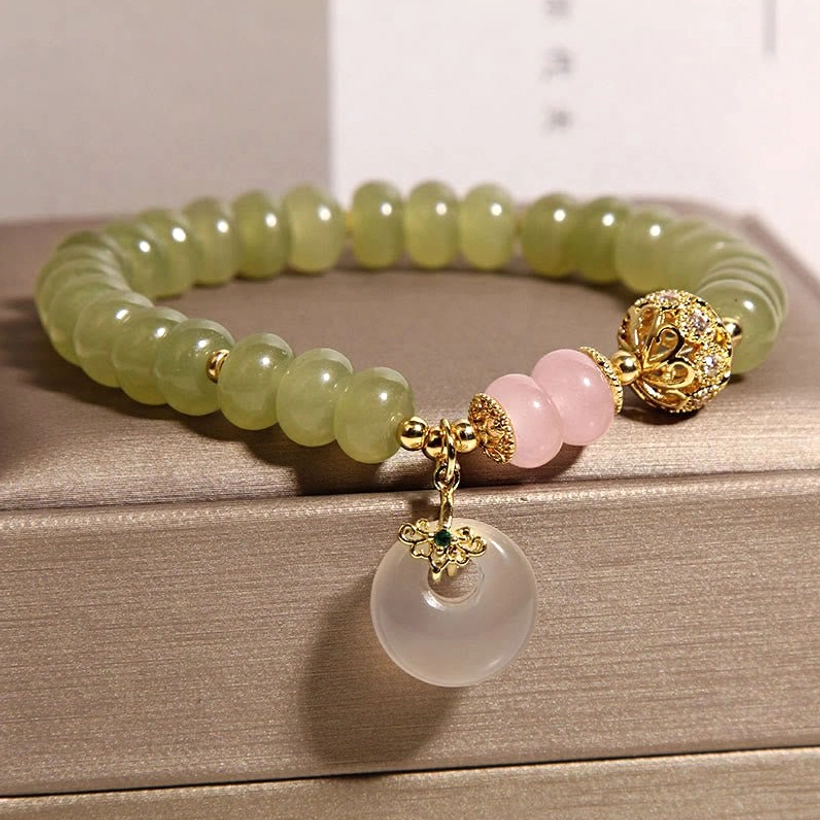 Green jade prosperity bracelet with rose quartz, gold decorative bead, and hanging peace buckle charm side view