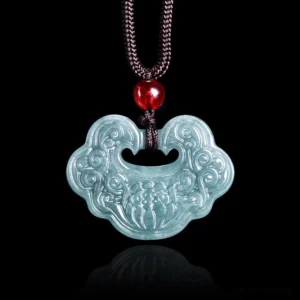 Front-facing close-up of jade ruyi lock pendant with woven brown cord and single red glass bead on black background
