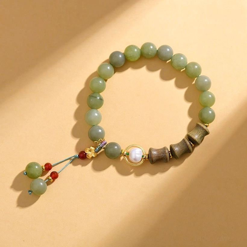 Jade beaded bracelet overhead view featuring round jade beads, bamboo sandalwood charm, and decorative tassel