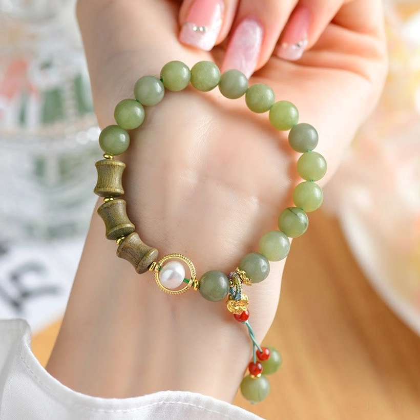 Woman's hand wearing jade sandalwood bamboo pearl bracelet showing comfort fit and daily wear styling
