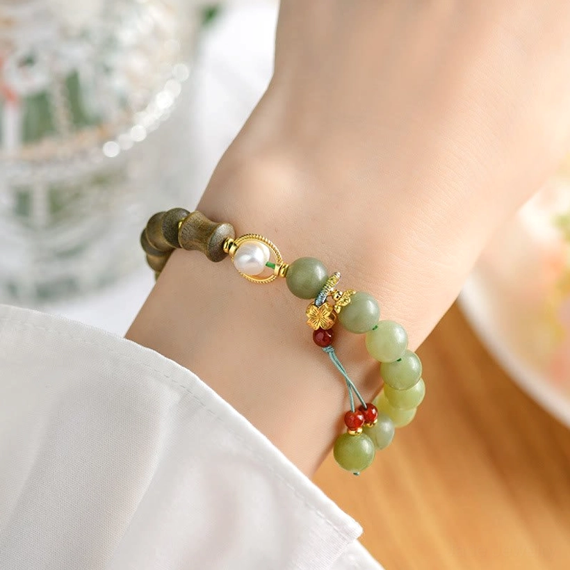 Jade sandalwood prosperity bracelet worn on wrist showing jade and sandalwood beads with decorative tassel