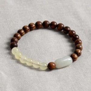 Premium jade sandalwood prosperity bracelet close-up showing intricate beadwork and barrel-shaped jade bead detail