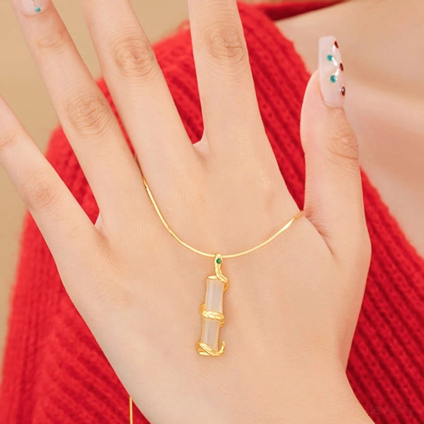 Hetian jade snake bamboo pendant worn on female hand - showing scale and delicate proportion of the jewelry piece