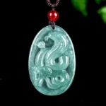 Natural jade snake zodiac pendant necklace on dark background with green foliage, year of the snake 2025