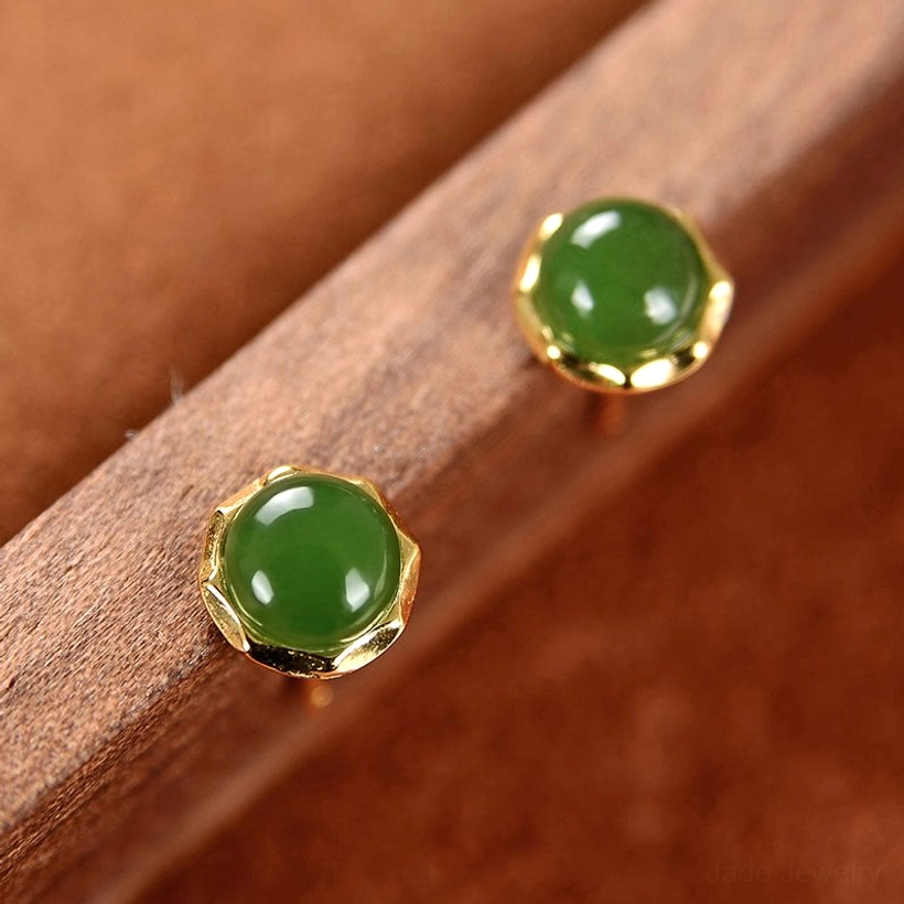 Woman wearing delicate cyan jade stud earring on earlobe showing mini jade stud worn effect against skin