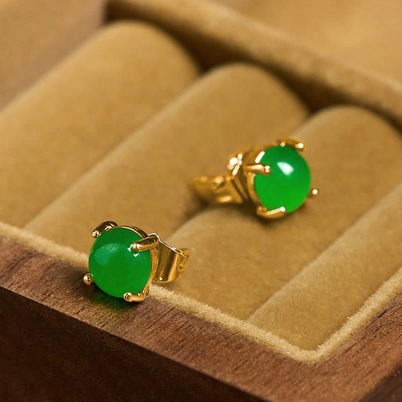 Pair of jade stud earrings in 925 sterling silver gold setting displayed in velvet jewelry box