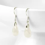 Jade teardrop dangle earrings with 925 sterling silver fishhook earwires on white ceramic background, front view showing milky white and silvery tones