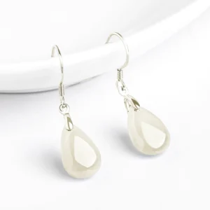 Faceted natural jade teardrop charm earrings in sterling silver, side top-down view highlighting the smooth polished jade pendants