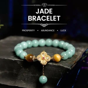Jade yellow tiger eye prosperity bracelet with metal four-leaf clover charm and dangling jade bead on dark stone background