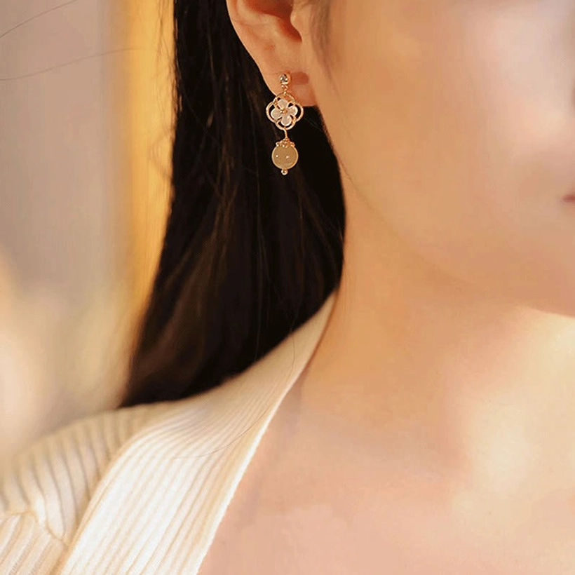 Hetian jade drop earrings worn on earlobe, side neck close-up showcasing the floral design and jade bead dangle in casual daily styling