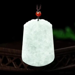 Natural jade zodiac pendant front view detail showing smooth polished carving, light green celadon jade with adjustable brown rope slip-knot closure