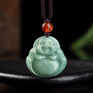 Laughing Buddha cyan jade pendant necklace front view on black ceramic tray, handcrafted with polished green jade and brown braided cord