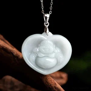 Heart-shaped laughing Buddha white jade pendant necklace with titanium steel chain, front flat view on dark wooden backdrop