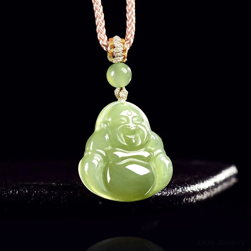 Laughing Buddha jade pendant hanging on display rod showing carved Buddha face and smooth finish