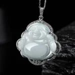 Laughing Buddha jade pendant necklace close-up showing carved smiling face with crystal-studded titanium steel frame