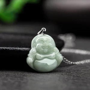Side profile of intricately carved Laughing Buddha jade pendant showing detailed Buddha face with serene expression, light green jade, silver hanging clasp and chain