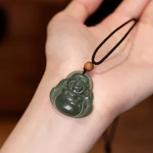 Laughing Buddha jade pendant necklace worn on wrist, showing dark cyan carved Buddha with black adjustable cord and wooden bead detail