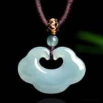 Light cyan Ruyi jade lock pendant necklace front view, showing polished cloud-shaped design with hollow heart center, brown braided cord with golden accents on dark studio background