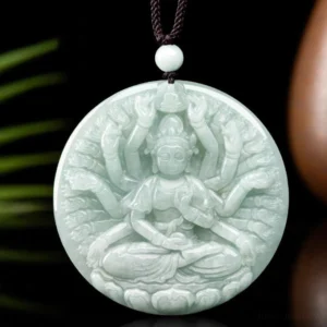 Light green jade thousand-hand Guanyin pendant displayed on green leaf background with dark cord