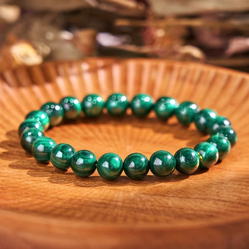 Light green tiger eye jade balance bracelet, flat lay display showing polished striped beads in light green and neutral tones