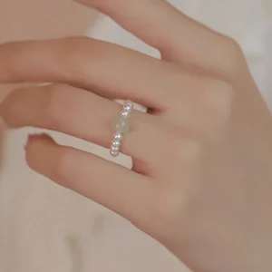 Light color jade pearl beaded ring worn on finger close-up detail view