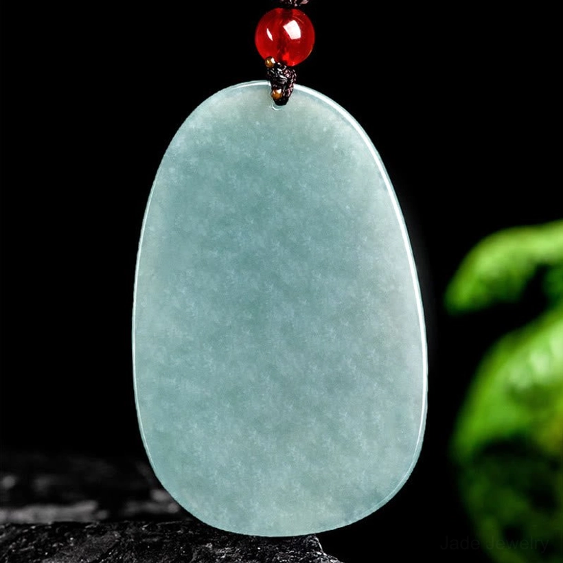 Plain polished light cyan jade pendant necklace with red bead and brown cord, uncarved smooth surface