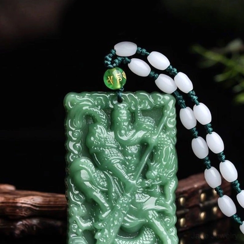 Lord Guan jade protection pendant close-up showing intricate hand-carved details of Guangong figure, sacred dragon motif, and fine artisan craftsmanship