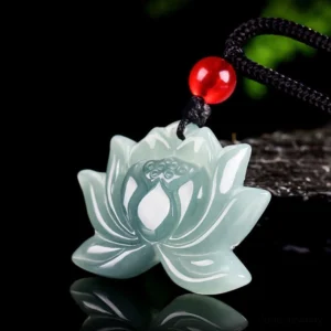 Hand-carved jade lotus pendant showing 3D relief carving detail with smooth polished finish and red accent bead