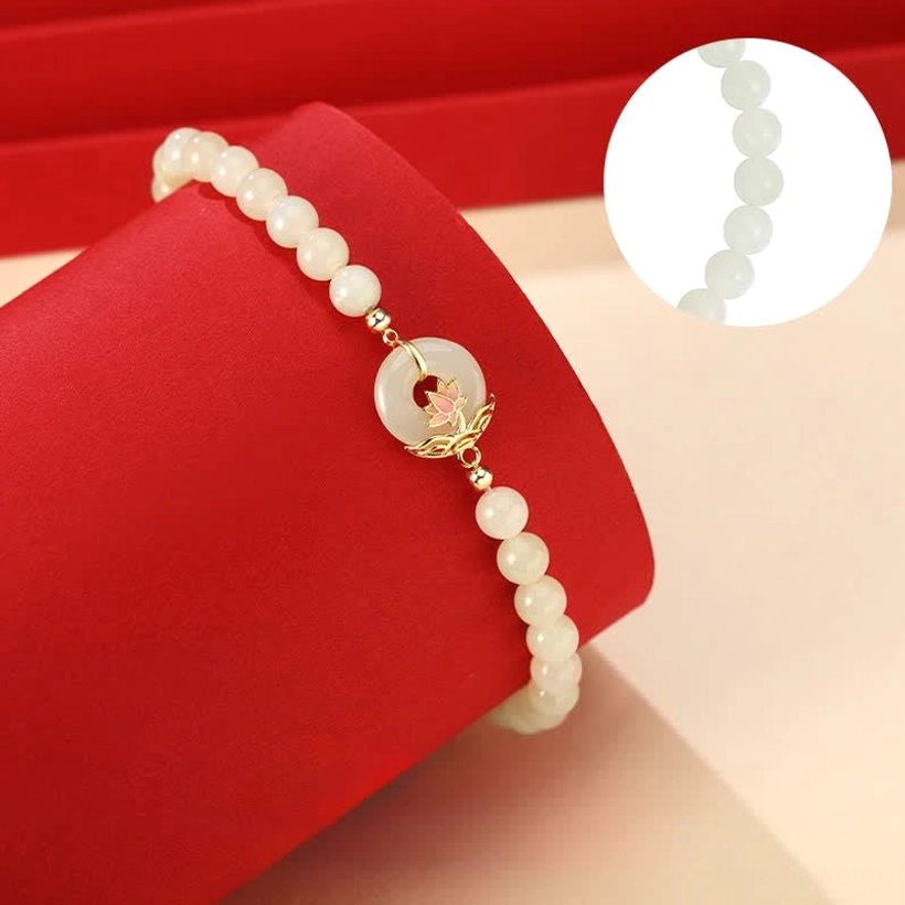 Hetian jade lotus bracelet oblique angle showing delicate jade bead texture, sterling silver hardware, and decorative charm