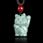 Maneki Neko jade lucky cat pendant front view, light green polished jade with raised left paw, red bead and black cord necklace