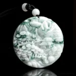 Mountain landscape jade pendant necklace featuring natural green jade with carved pavilions and pine trees, shown in front top-down view on black background