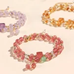 Multi-style natural crystal healing bracelets featuring strawberry quartz, moonstone, citrine, and more gemstones in flat lay arrangement