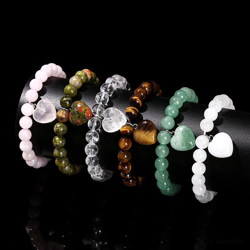 Collection of five natural stone heart bracelets - green aventurine, white jade, clear crystal, pink crystal, and tiger eye variants