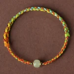 Multicolor braided jade bead bracelet top view with light green jade centerpiece and metal spacers