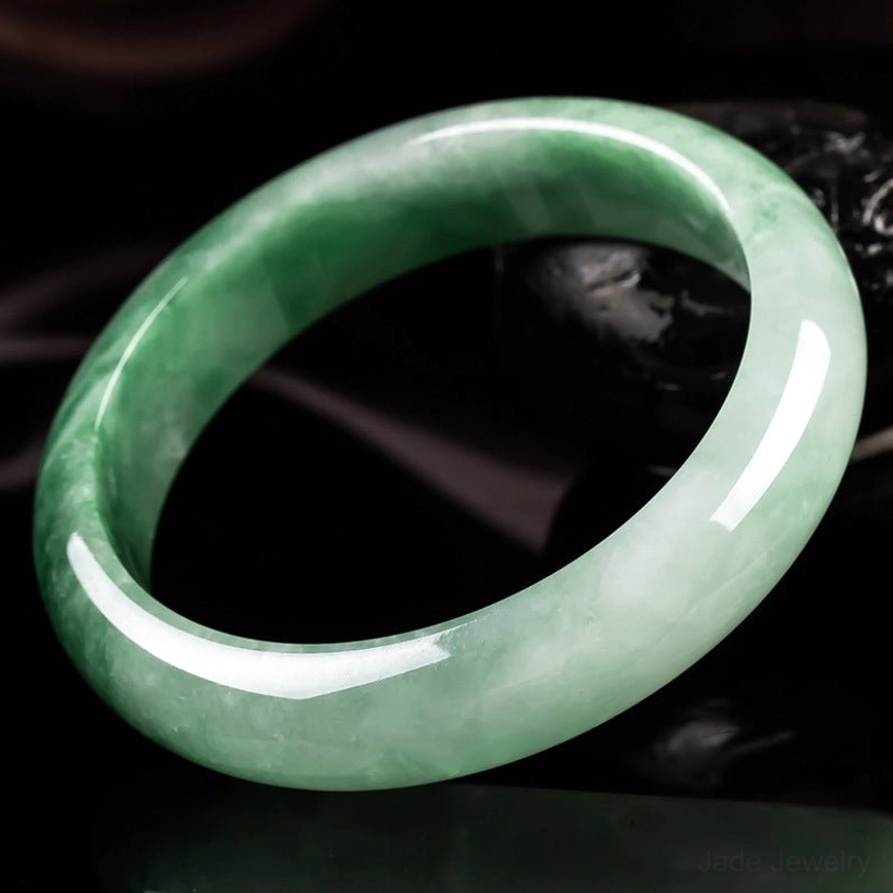 Premium jade bangle with dominant dark green streaks on light jade base, high-gloss polished finish