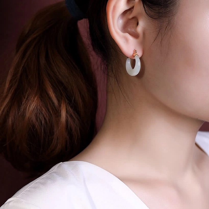 Single natural jade drop earring worn on earlobe in close-up portrait view, demonstrating minimalist elegant daily wear style and perfect fit