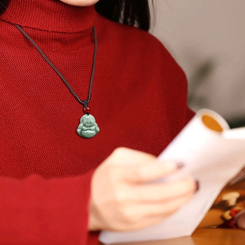 Complete natural jade Laughing Buddha Maitreya necklace package showing pendant with adjustable black braided cord and traditional red accent bead