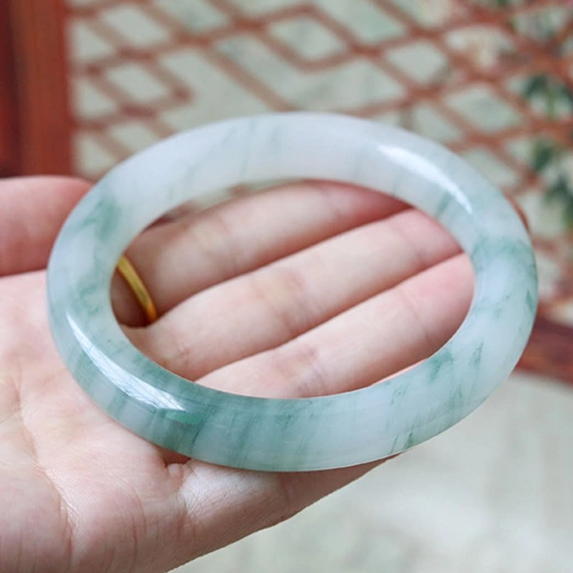 Natural jade bangle bracelet for prosperity and wealth attraction, authentic handcrafted piece with green veining and smooth polished finish