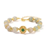 Natural jade prosperity bracelet with 8mm polished jade beads and gold chain clasp on pink background - handmade jade jewelry for abundance