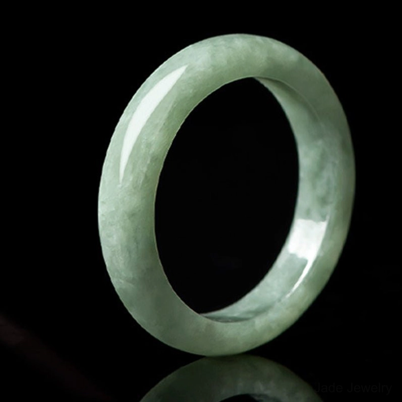 Polished natural jade prosperity ring thick band front view reflective studio lighting