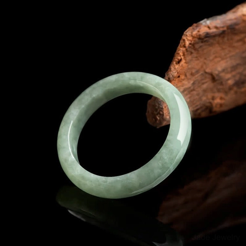 Natural jade prosperity ring with veined pattern side view wooden studio background