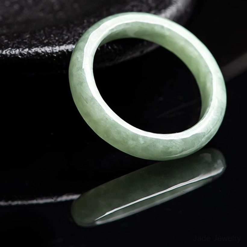 Natural jade prosperity ring side view with jade stone slab black display stand