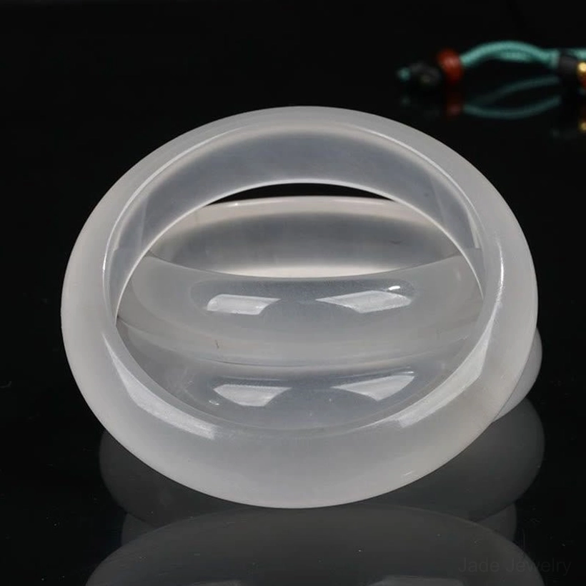 Nested golden silk jade bangles in top-down arrangement showing glossy polished translucent white surface