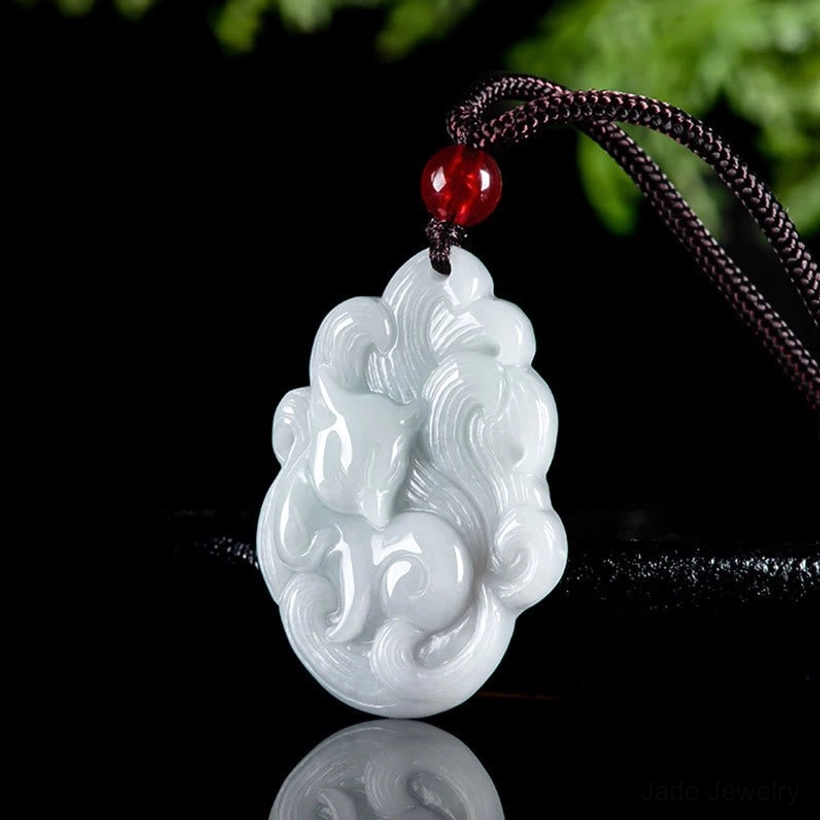 Overhead perspective of white jade nine-tailed fox pendant with cloud pattern carving