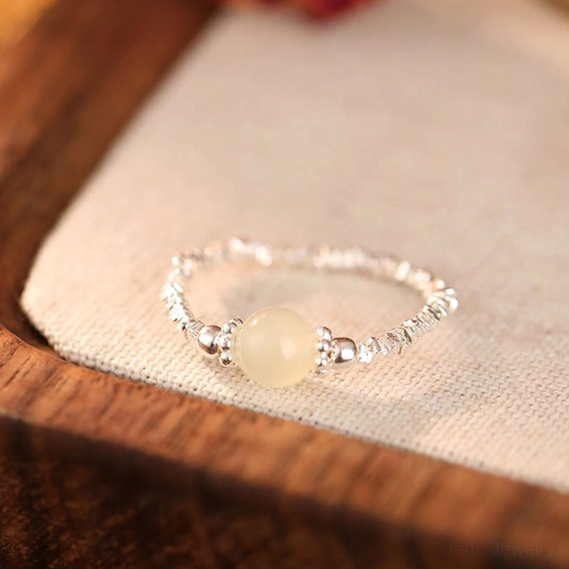 One jade bead elastic adjustable ring with 925 sterling silver - detail shot on natural surface