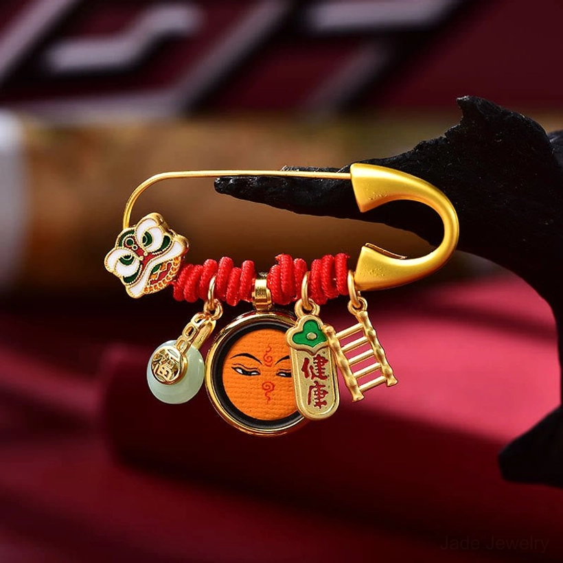 Orange finish dancing lion brooch with enamel face charm and ladder ornament detail