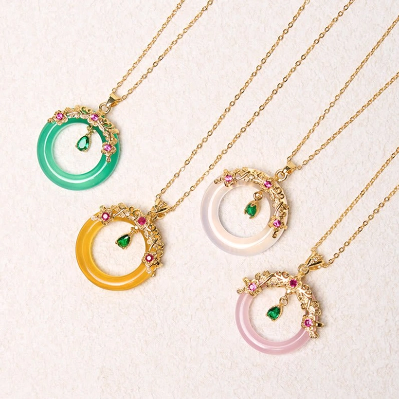 Four color variants of peace buckle necklaces with green, pink, white and yellow chalcedony gemstones flat lay