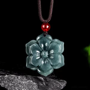 Handcarved peach blossom jade pendant necklace, dark polished jade with intricate layered flower design and red accent bead on brown cord